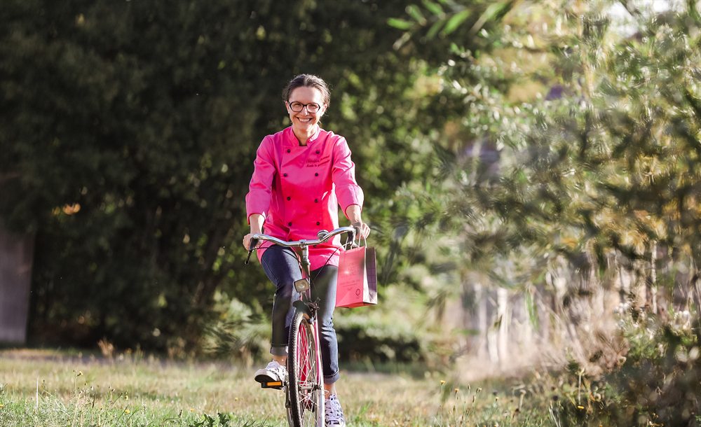 Clémence à vélo avec un sac Made In Gourmandise